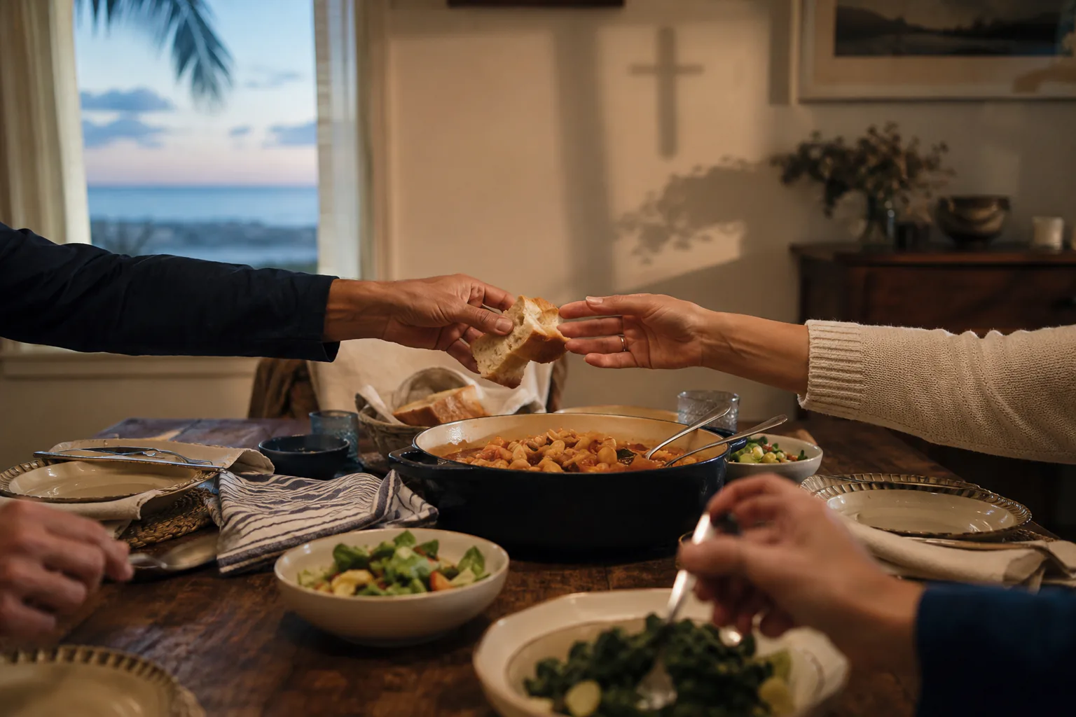 Familiares compartiendo pan alrededor de una mesa en Palm Beach al atardecer